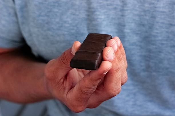 istock chocolate bar in hand, man holding chocolate bar in hand 2238779897