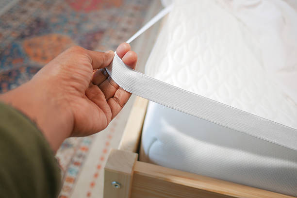 istock Adjusting the fitted sheet on a bed during home organization 2238785400