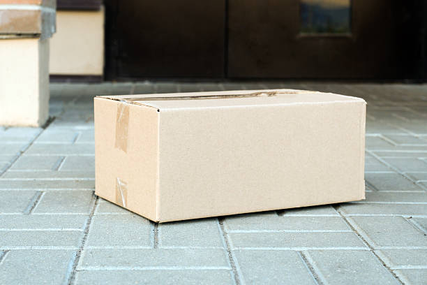 istock Delivery package box waiting on doorstep outside home 2238785664