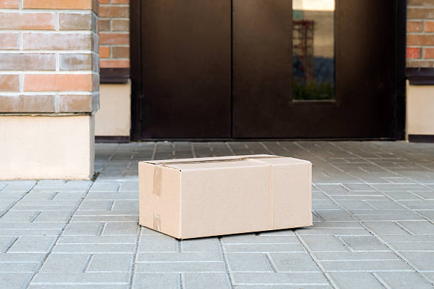 istock Cardboard package delivered to front home door contactless 2238785755