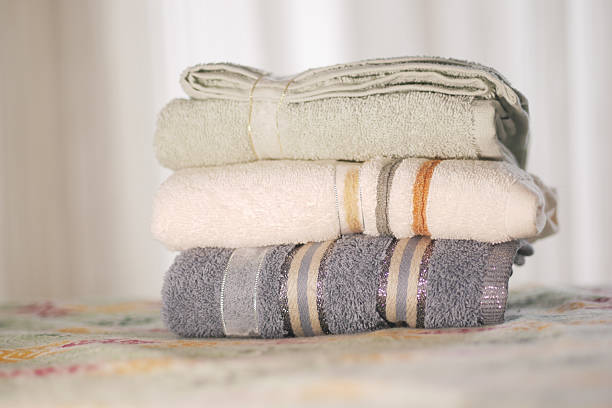 Soft towels stacked neatly on a bed .