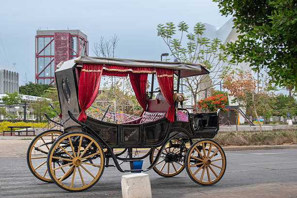Guadalajara, Mexico - May 29 2025: Classic decorative calandria parked near public park with modern sculpture at Glorieta de la Normal, Guadalajara, Jalisco, Mexico