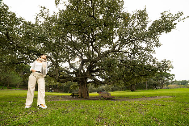 istock Young woman enjoying nature standing under large tree 2238788385