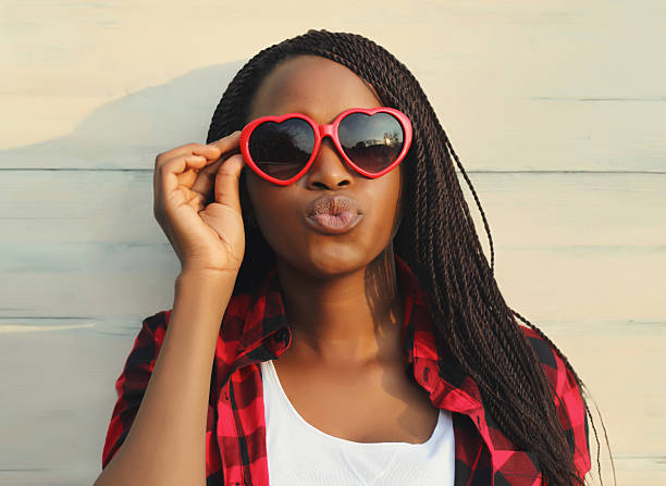 Happy young African woman in red heart shaped glasses, beautiful black girl in sunglasses stock photo