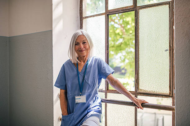 istock Tired nurse taking break, standing by old widnow. 2238792289