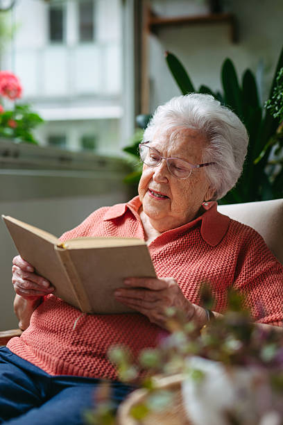 istock Senior lady sitting at balcony, reading book. 2238794825