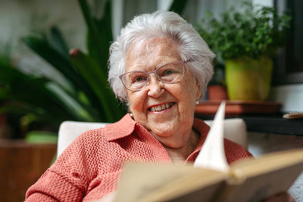 istock Senior lady sitting at balcony, reading book. 2238794860