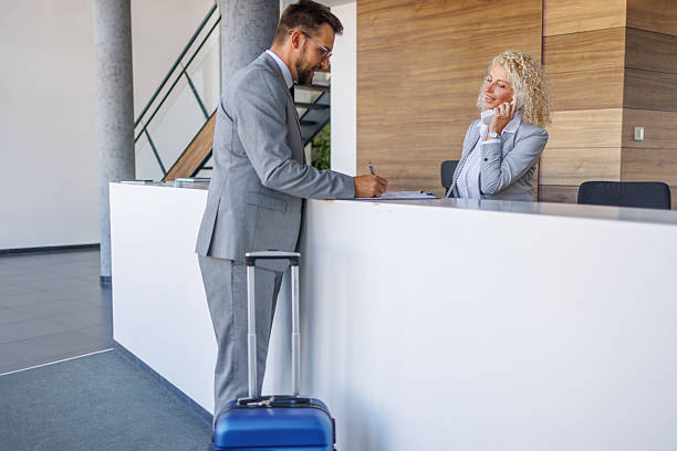 istock Businessman checking in at modern hotel reception desk 2238795124