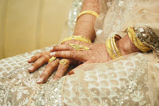 istock Exquisite bridal hands adorned with gold jewelry during celebration 2238795616