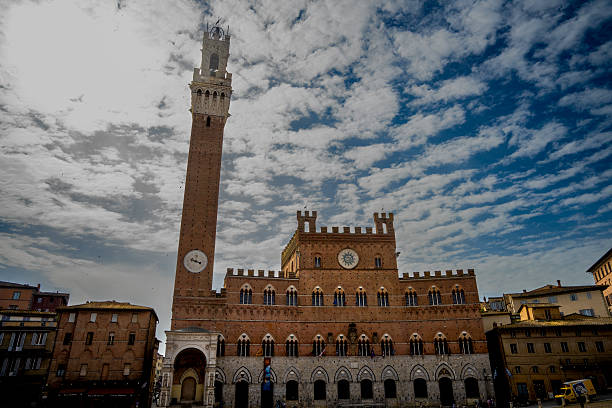 Palazzo Pubblico and Torre del Mangia in Siena, Italy, photographed on April 30, 2025, with clouds above Piazza del Campo.
