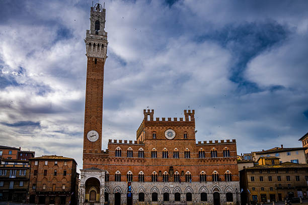 Palazzo Pubblico and the Torre del Mangia in Siena, Italy, photographed on April 30, 2025, beneath dramatic clouds over Piazza del Campo.
