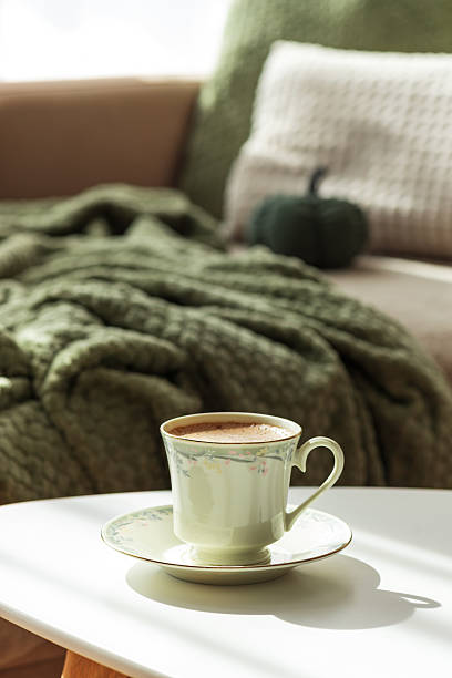 istock Cozy Autumn Scene with Green Cup of Coffee and Sofa Decor 2238806501