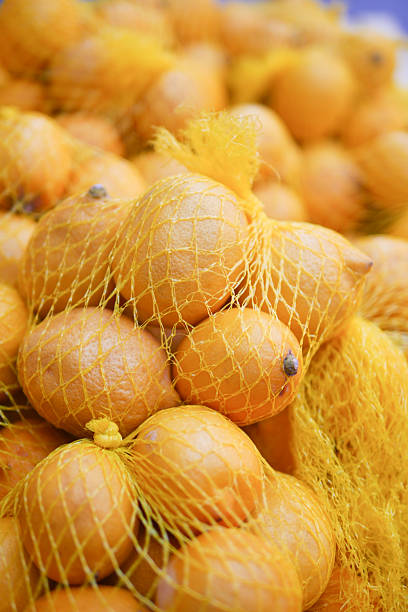 istock Fresh lemons in yellow netting at a market 2238810979