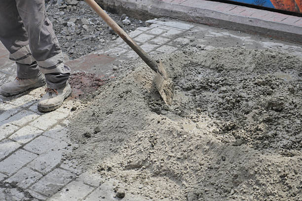 istock Worker shoveling concrete on s busy site 2238811712
