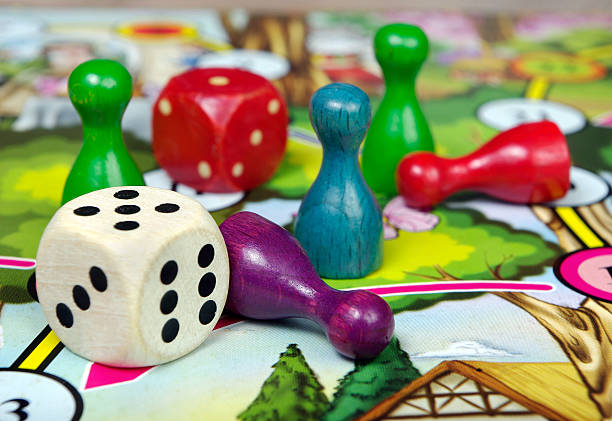 istock colorful play figures with dice on board 2238812141