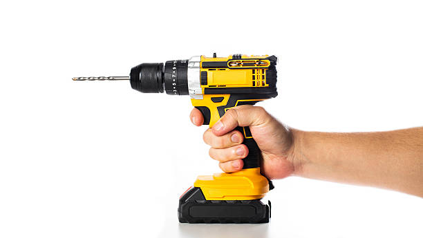 istock Hand holding a yellow power drill ready for home improvement tasks or DIY projects indoors, isolate 2238824005