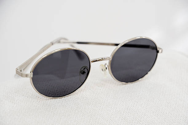 istock Glasses in a silver metal frame with gray lenses on a white background 2238825156