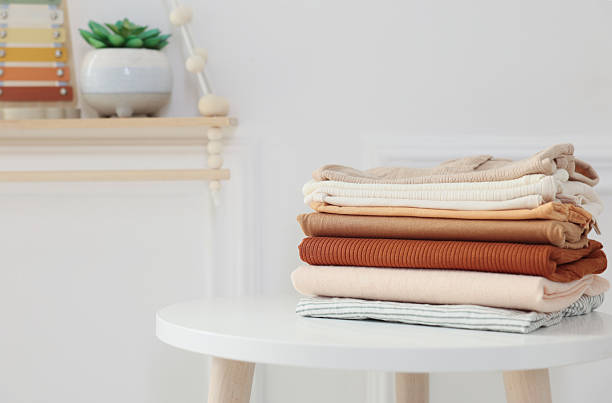 istock Stack of clean baby clothes on white table indoors, space for text 2238829106