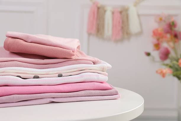 istock Stack of clean baby clothes on white table indoors, closeup 2238829137
