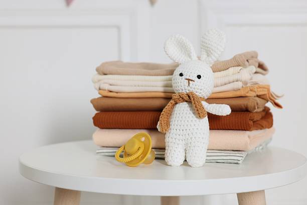 istock Stack of clean baby clothes and accessories on white table indoors, closeup 2238829145