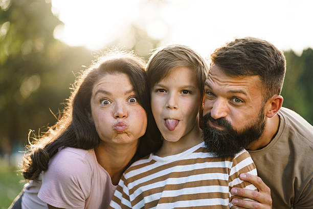 istock Family making funny faces outdoors together 2238829633