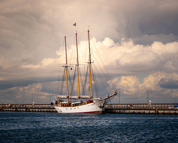 Poland, Hel - 01 September 2011.The iconic tall ship 'Kapitan Borchardt' is docked at Hel port in Poland, surrounded by people and evening light. This editorial photo highlights maritime history and tourism with detailed rigging and a vibrant sky.