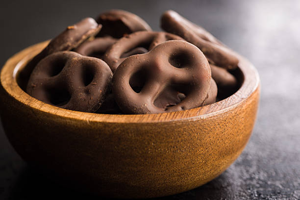 istock Chocolate covered pretzels on black table. 2238833400