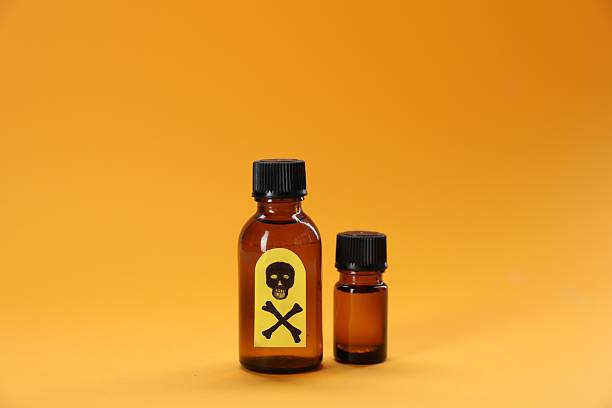 istock Bottles of poisons with warning sign on orange background 2238834962