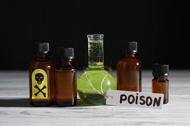 istock Bottles with poisons on wooden table against black background 2238835153