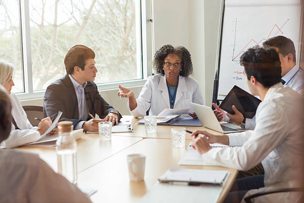 istock Medical professionals in a meeting discussing charts and data on laptops and tablets. 2238837224