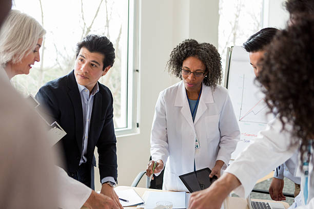 istock Diverse healthcare professionals collaborate during a meeting, discussing plans on tablets and whiteboards. 2238837231
