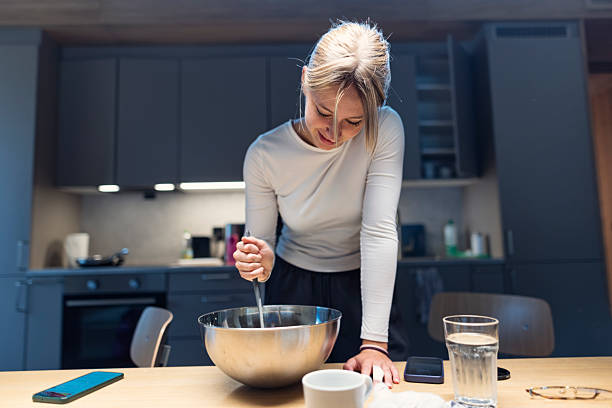 istock Happy young woman stirs batter in cozy modern kitchen 2238842902