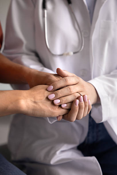 istock Young female general practitioner calming patient, holding hands 2238844687