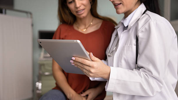 istock Hands of female doctor holding tablet, using electronic records 2238846490