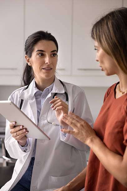 istock Serious young Hispanic female practitioner talking to patient 2238847505