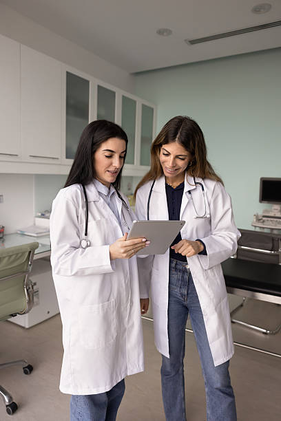 istock Positive female doctor friends using tablet computer together 2238854245