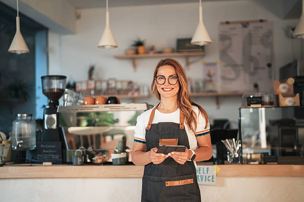 Smiling beautiful waitress with tablet in modern coffee shop