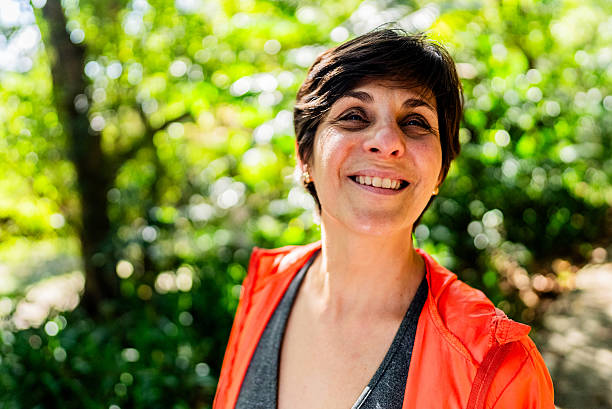 istock Smiling woman contemplating nature outdoors in forest 2238870105