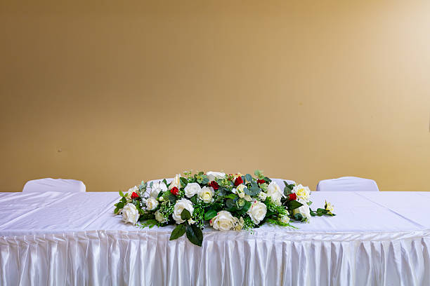Waitress working at a restaurant and setting a table putting beautiful flowers
