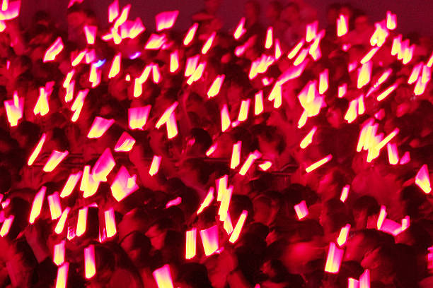 Passionate audience waving red glow sticks at the concert
