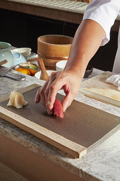 Sushi Chef Serving Maguro Nigiri on Stone Plate