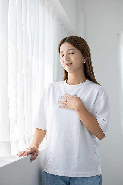 istock Woman taking deep breath and relaxing by window 2238891961