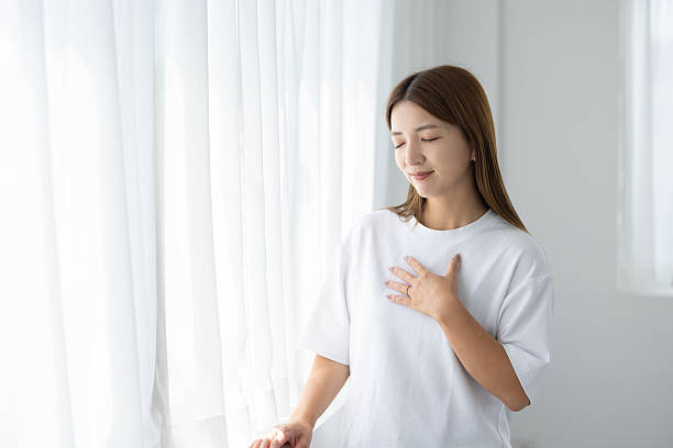 istock Woman taking deep breath and relaxing by window 2238891963