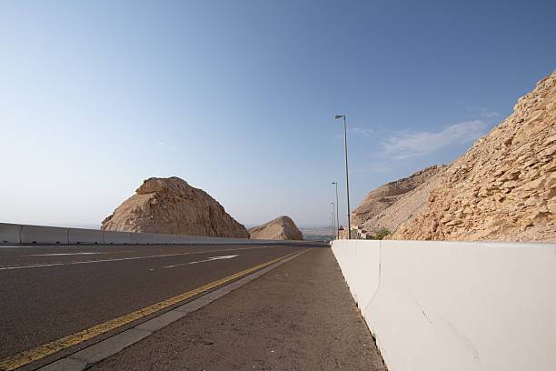 Scenic landscapes and mountain roads around Jebel Hafeet in Al Ain, United Arab Emirates, showing desert terrain, rocky hills, and winding routes under clear skies.