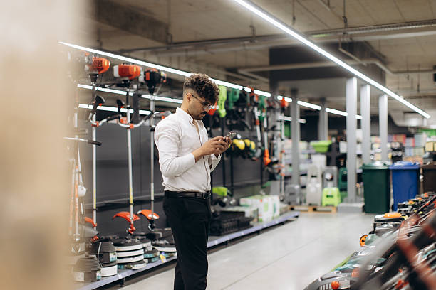 istock Young Professional Browsing Mobile Phone in a Hardware Store 2238894278