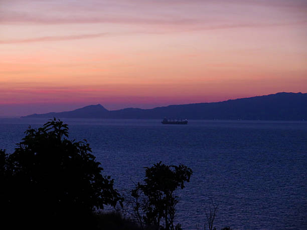 The sky glows in shades of purple and orange over the calm sea.