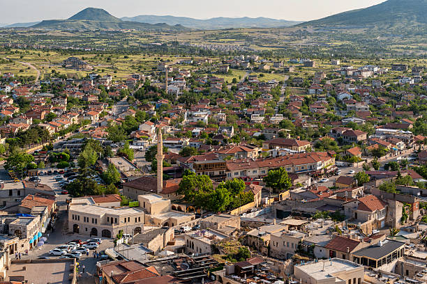 Cappadocia, Turkey - June 10, 2025: High-angle view of Uchisar, from Uchisar Castle. Features traditional architecture, a mosque minaret, and surrounding landscape