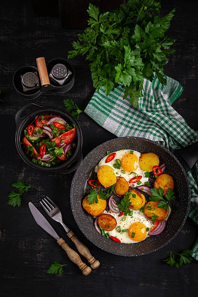 istock Fried eggs and potatoes with onions and chili peppers in a rustic style. Top view, flat lay 2238900044