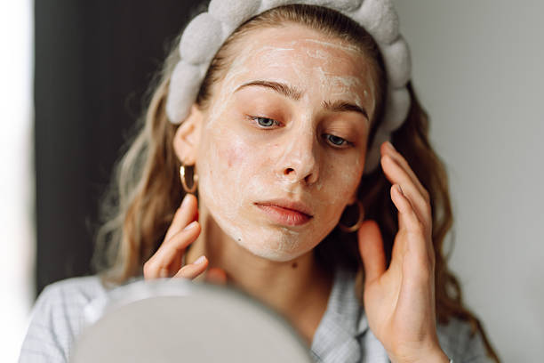 istock A close-up of a young woman's face with a mask reflected in a small mirror. 2238900252