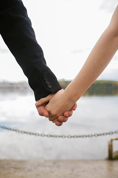istock Couple Holding Hands By The Lake 2238900321
